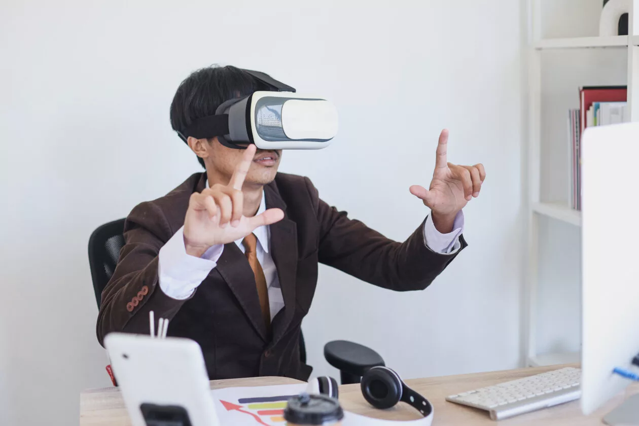 Man Wearing Vr Goggles Mimes Square At Desk