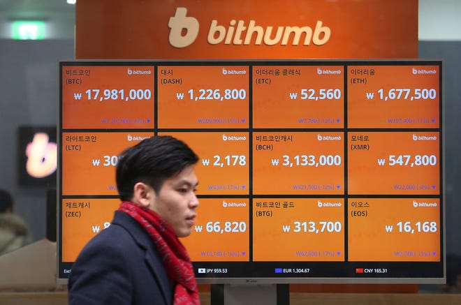 A Man Passes By A Screen Showing The Prices Of Bitcoin At A Virtual Currency Exchange Office In Seoul, South Korea, Tuesday, Jan. 16, 2018.